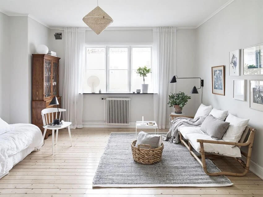 Phòng khách phong cách Bắc Âu với ghế sofa trắng, ánh sáng tự nhiên từ cửa sổ lớn và đồ nội thất gỗ.