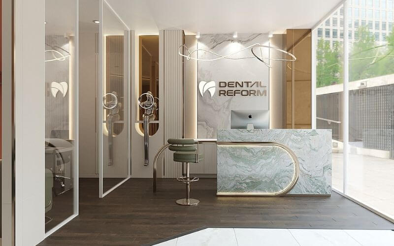 Phòng khám nha khoa hiện đại với quầy lễ tân đá cẩm thạch và logo phòng khám trên tường.