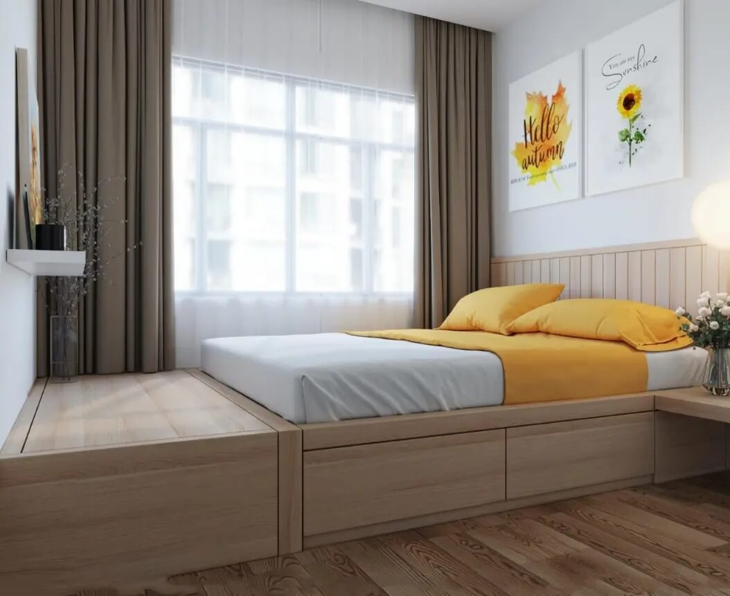 Phòng ngủ với giường gỗ và chăn ga gối màu vàng, có cửa sổ lớn và tranh treo tường trang trí.