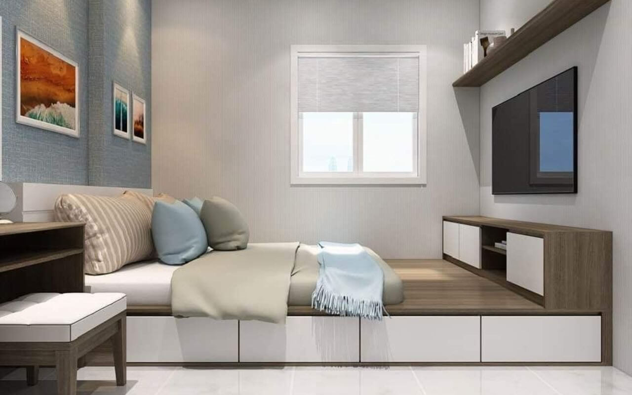 Phòng ngủ hiện đại với giường gỗ, kệ sách và tivi treo tường, ánh sáng tự nhiên qua cửa sổ.