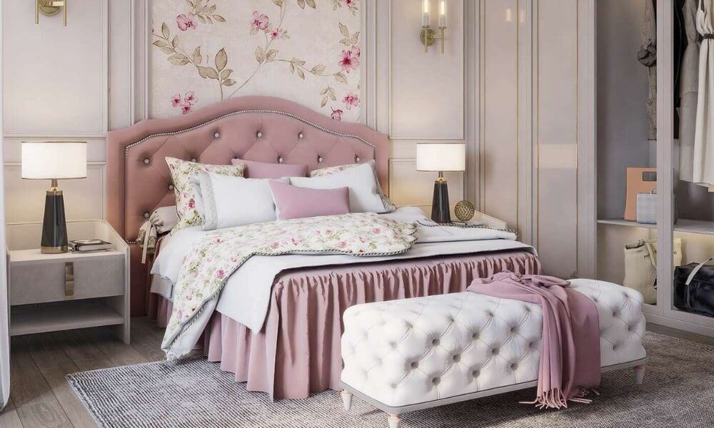 Phòng ngủ sang trọng với giường bọc đệm hồng, đèn bàn và giấy dán tường hoa hồng, tủ quần áo mở.