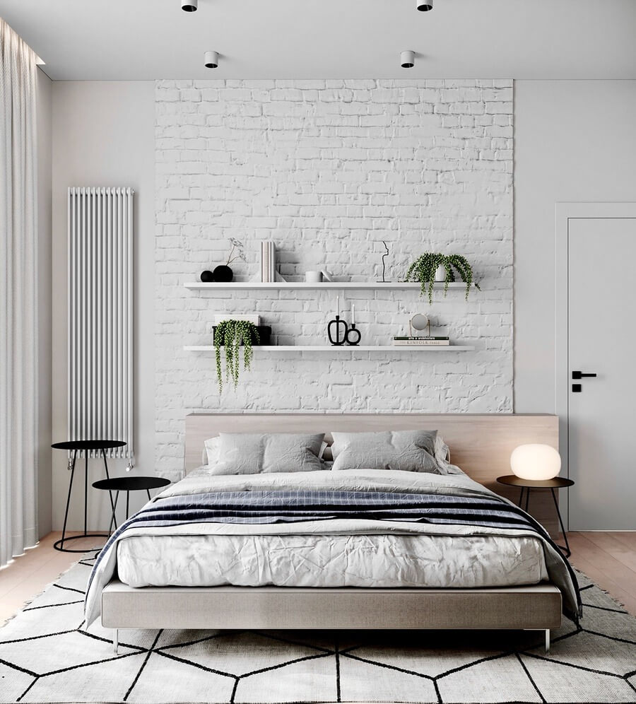 Phòng ngủ hiện đại với tường gạch trắng, giường đôi, đèn ngủ và kệ trang trí.