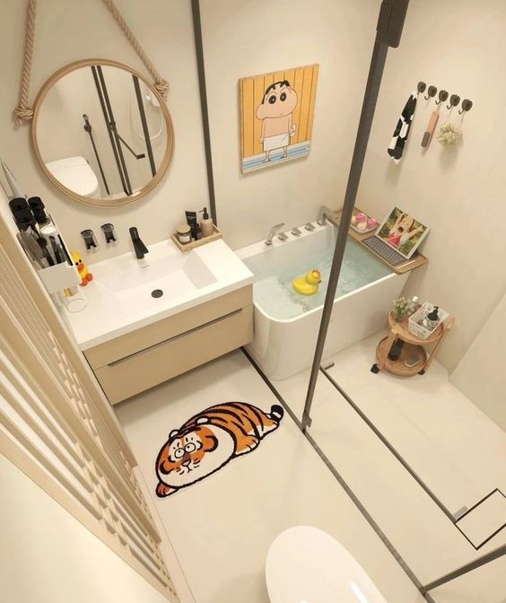 Phòng tắm nhỏ gọn với bồn tắm, gương tròn, thảm hình con hổ, và trang trí tranh tường.