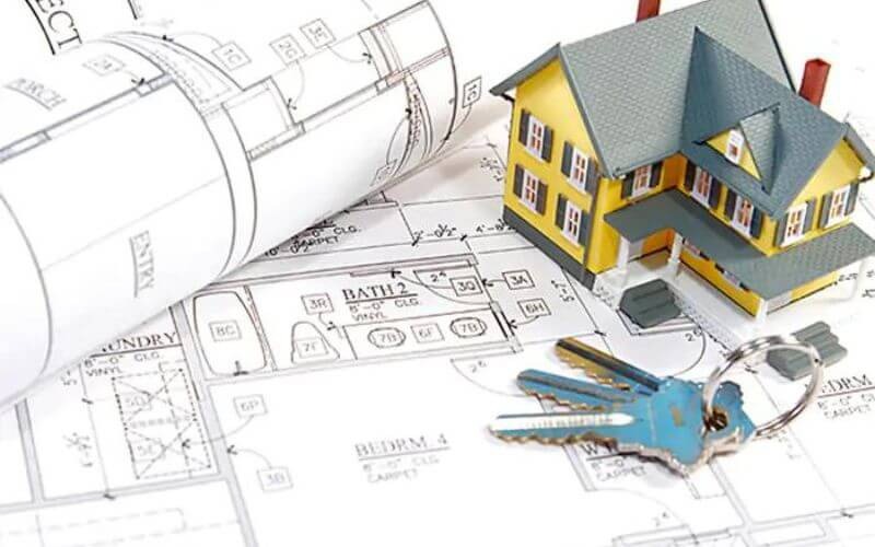 Bản vẽ kiến trúc với mô hình nhà nhỏ và chìa khóa, biểu tượng cho kế hoạch xây dựng và sở hữu nhà.
