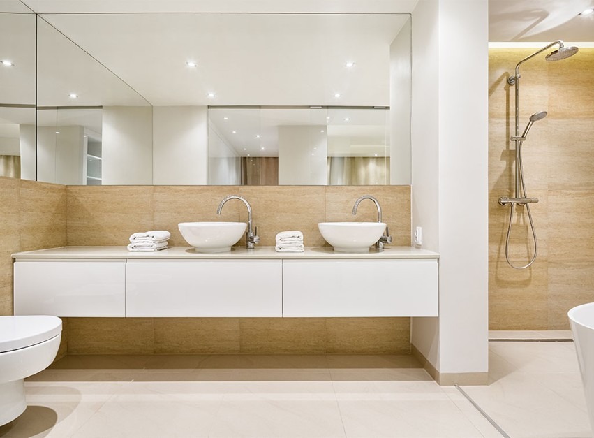 Phòng tắm hiện đại với bồn rửa đôi, vòi hoa sen và thiết kế gương lớn.