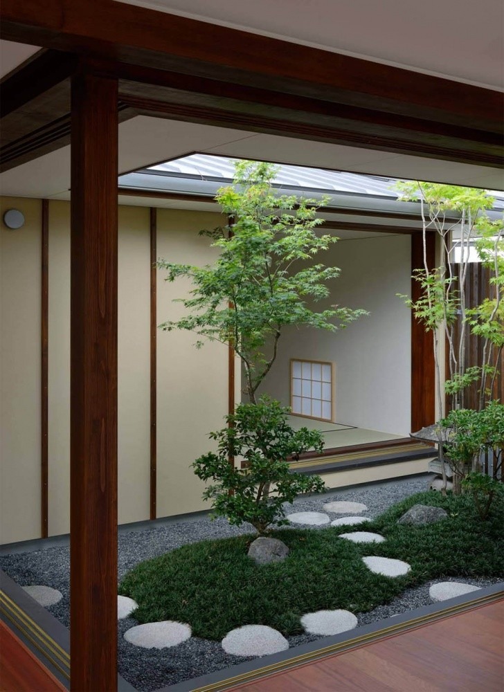 Sân vườn Nhật Bản truyền thống với cây xanh và lối đi lát đá, tạo không gian hài hòa và yên bình.