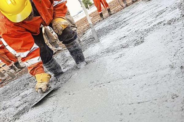 Công nhân đang xử lý bê tông tươi trên công trường xây dựng, đảm bảo bề mặt phẳng và đều.