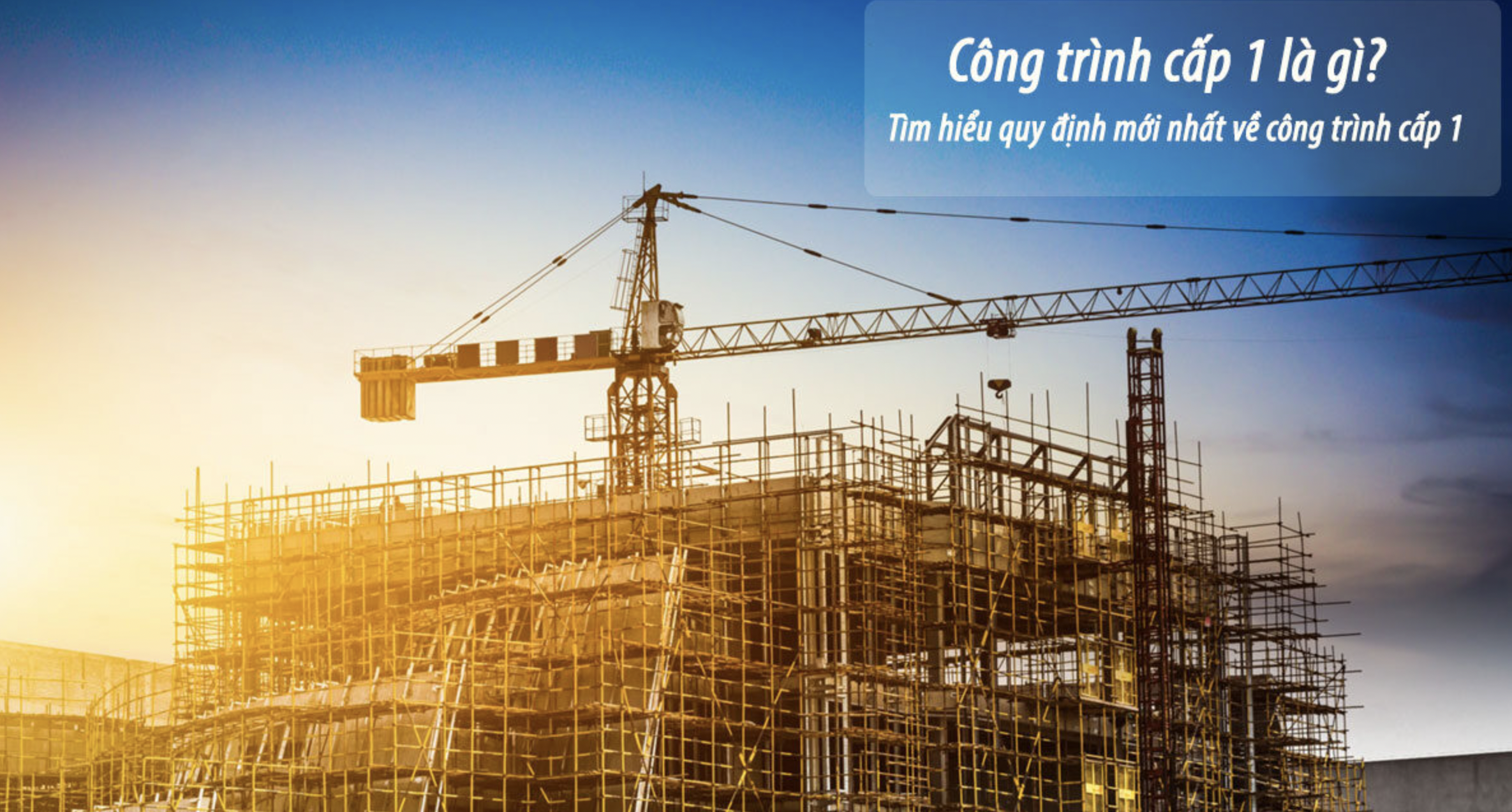Công trình xây dựng cấp 1 với cần cẩu và giàn giáo, ánh hoàng hôn phía sau.