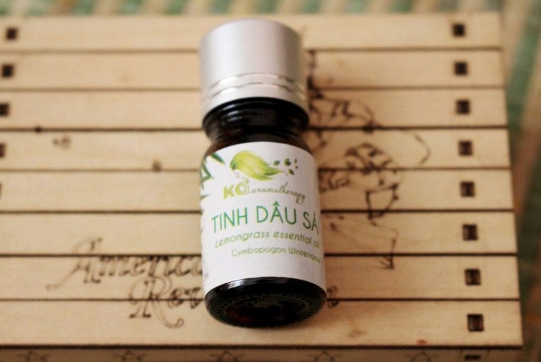 tinh-dau-tu-go-sa-mu Chai tinh dầu sả trên nền gỗ, nhãn hiệu KCI, dùng trong liệu pháp hương thơm.