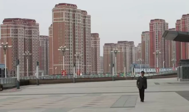 tpa Người đi bộ trên đường phố rộng với nhiều tòa nhà cao tầng ở phía xa.