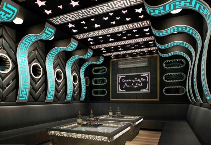 Phòng karaoke sang trọng với ánh sáng neon xanh và họa tiết sao trên trần.