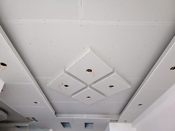 Trần thạch cao đơn giản với thiết kế ô vuông, có lỗ khoét chờ đèn, phù hợp cho trang trí nội thất.