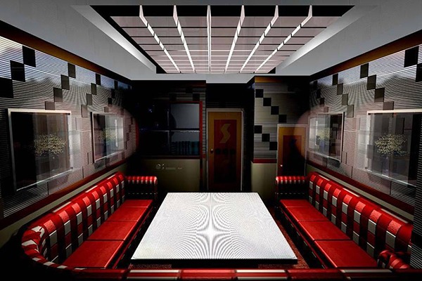 Phòng karaoke hiện đại với ghế sofa đỏ, bàn trung tâm và ánh sáng dịu. Thích hợp cho giải trí và hội họp.