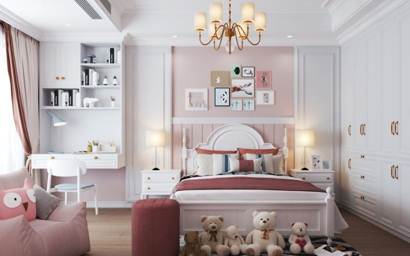 Phòng ngủ trẻ em màu hồng, trang trí dễ thương với gấu bông, đèn chùm và nội thất trắng thanh lịch.
