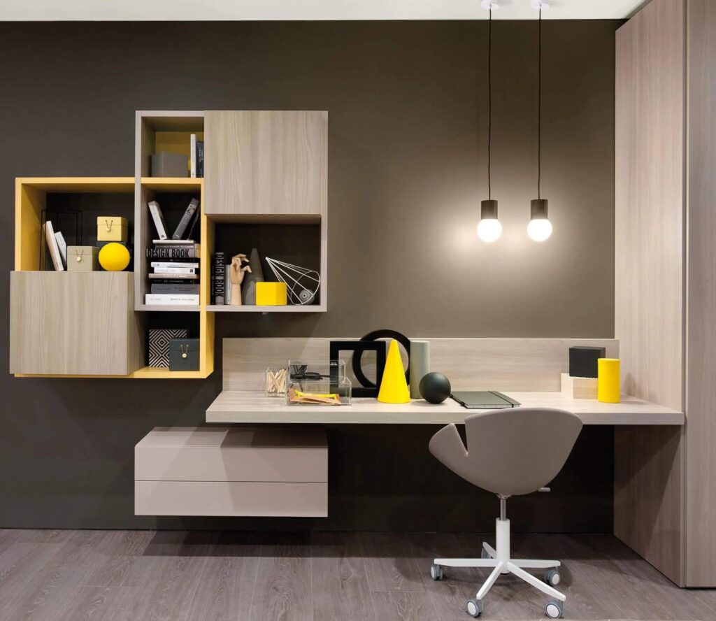 Bàn làm việc hiện đại với ghế xám, kệ gỗ, đèn treo và đồ trang trí tối giản, tông màu vàng-xám thanh lịch.