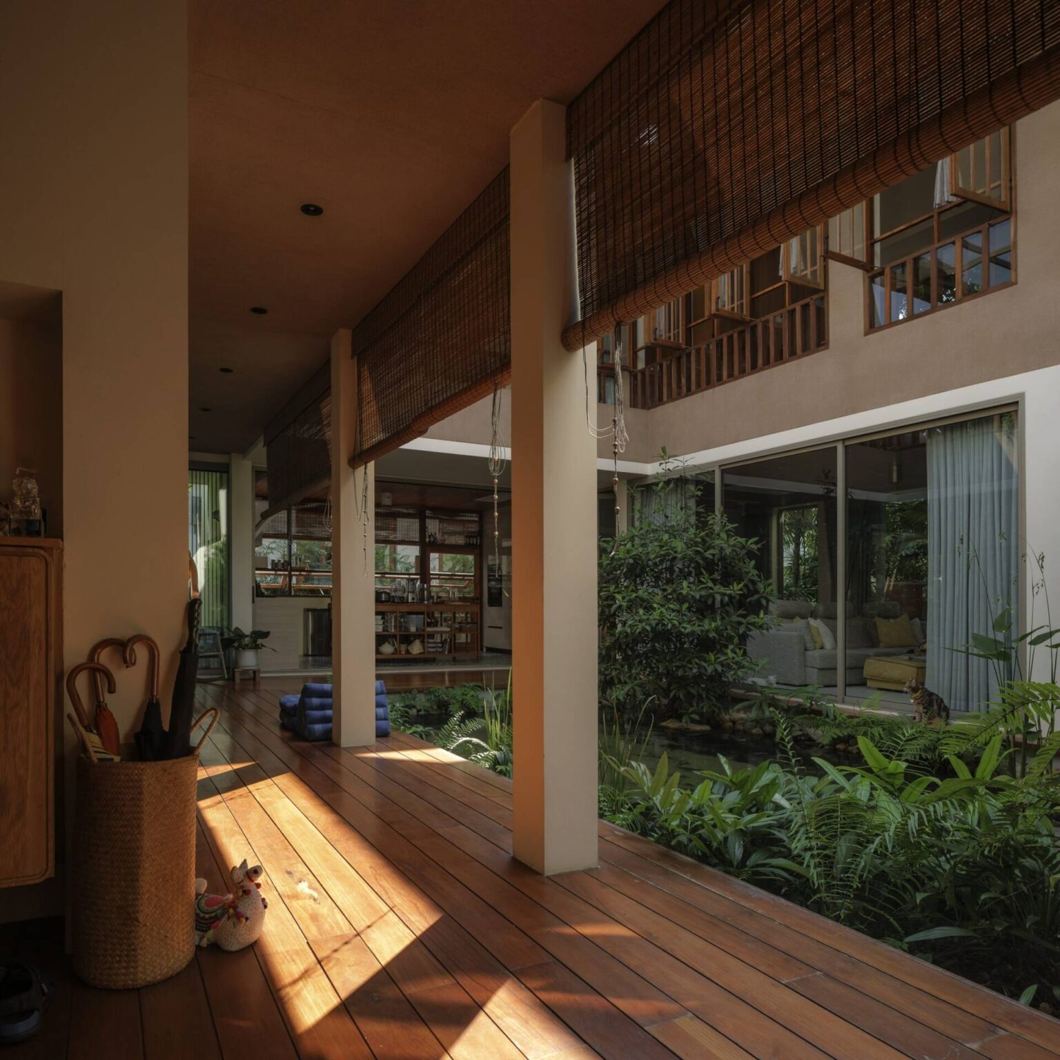 Hiên nhà gỗ với ánh sáng tự nhiên, cây xanh và nội thất mộc mạc, tạo cảm giác thư giãn và thoải mái.