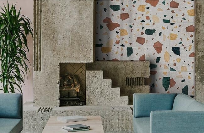 uewsmlxj1g5kap4v86qc Phòng khách với tường terrazzo, ghế sofa xanh lơ và cây xanh, tạo nên không gian hiện đại và ấm cúng.