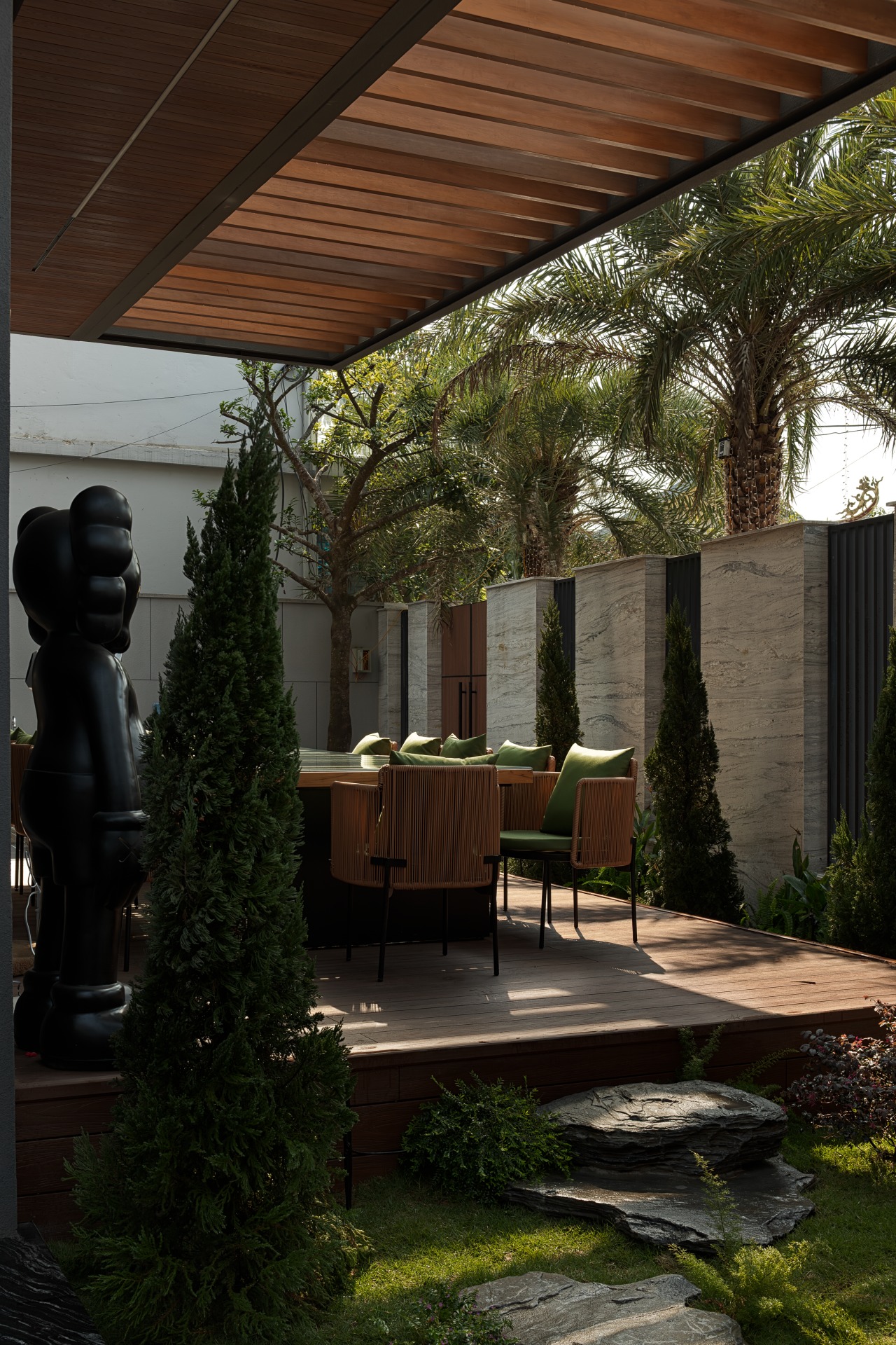 umi6886-enhanced-nr-edit Sân vườn xanh đẹp với tượng đen và bàn ghế ngoài trời, cây cối bao quanh tạo không khí thư thái.