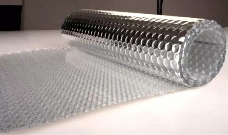 Cuộn màng xốp hơi trên bề mặt phẳng, dùng để đóng gói và bảo vệ hàng hóa.