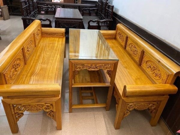 Bàn ghế gỗ truyền thống với thiết kế chạm khắc tinh xảo, kê trong phòng khách phong cách cổ điển.