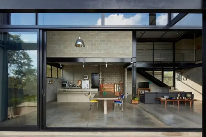 Không gian nội thất hiện đại với bàn ăn, ghế nhiều màu trong căn phòng thoáng đãng, ánh sáng tự nhiên từ cửa sổ lớn.