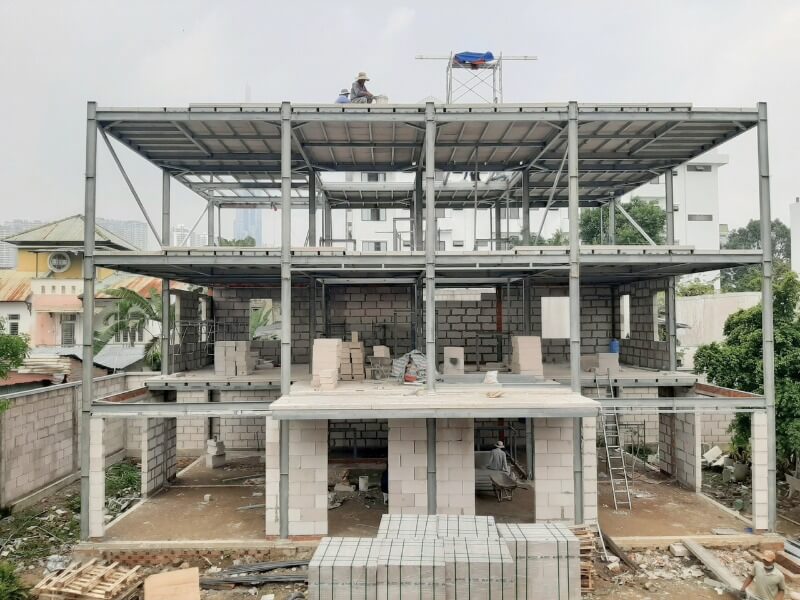 uu-diem-cua-nha-thep-tien-che-de-dang-ket-hop-voi-cac-phu-kien-ket-cau Xây dựng nhà khung thép, công trình đang trong quá trình thi công tại khu dân cư, sắt và bê tông đang lắp ráp.