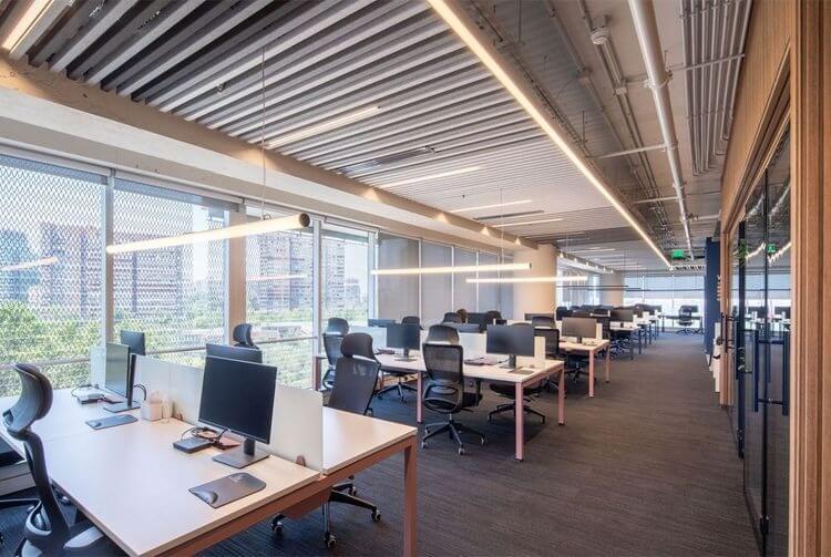 uu-diem-cua-noi-that-van-phong-mo-doi-voi-doanh-nghiep Văn phòng hiện đại với bàn làm việc và máy tính, ánh sáng tự nhiên từ cửa sổ lớn.