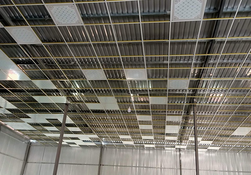 Trần nhà thép tấm lợp sóng công nghiệp với cấu trúc gạch vuông đều trong nhà xưởng.