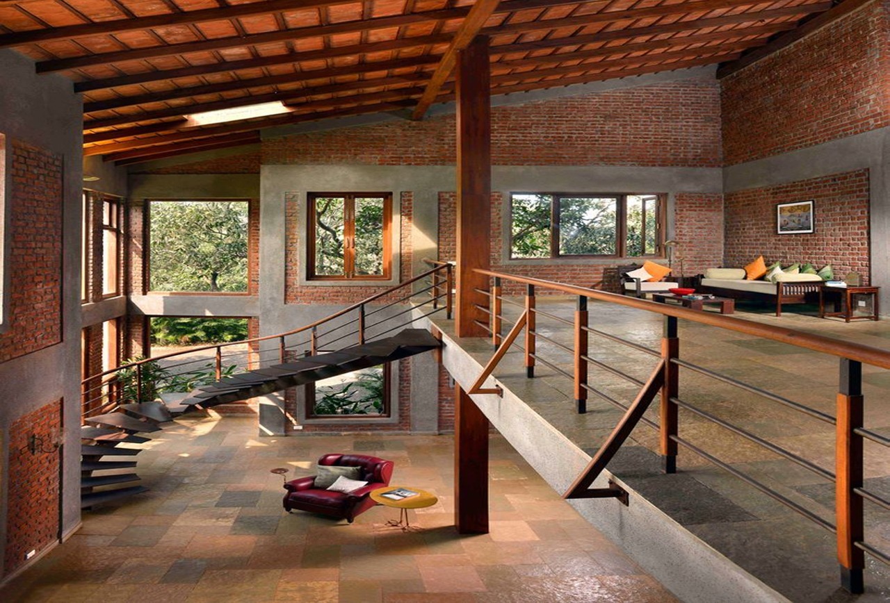 Phòng khách hiện đại với thiết kế mở và tường gạch, nội thất gỗ và ghế sofa thoải mái.