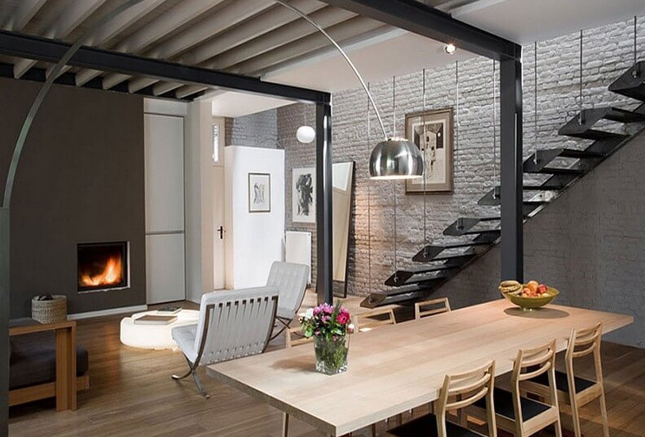Phòng khách hiện đại với cầu thang nổi, bàn gỗ dài và lò sưởi ấm cúng, tạo không gian thoải mái.