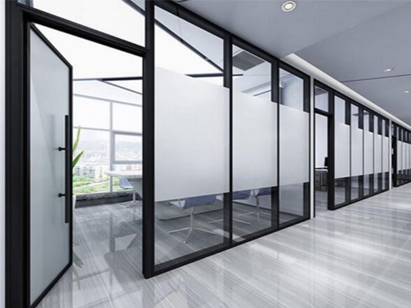 vach-kinh-cach-am Văn phòng hiện đại với tường kính và nội thất tối giản, tạo không gian làm việc sáng sủa và rộng rãi.
