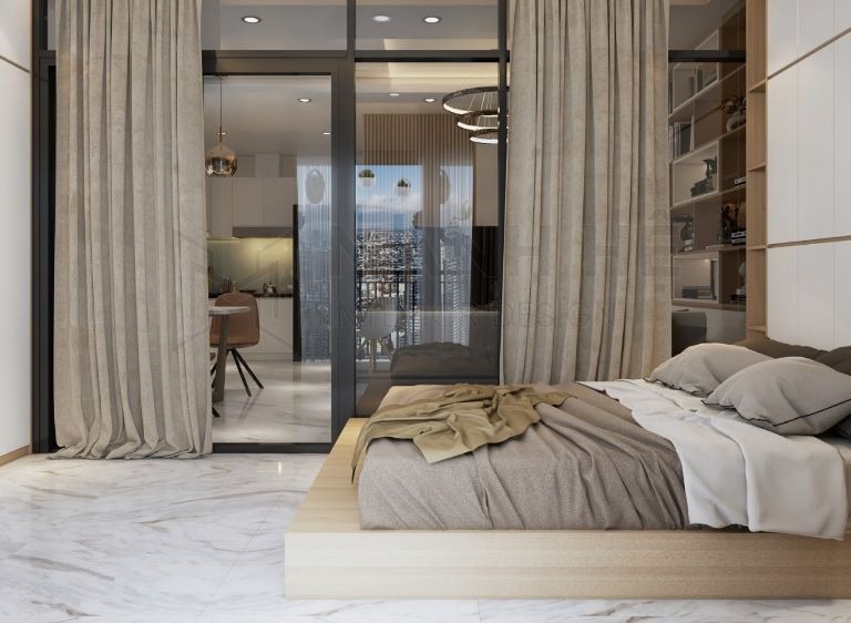 Phòng ngủ hiện đại với giường gỗ thấp, rèm cửa lớn, sàn gạch, cửa kính nhìn ra phòng khách.