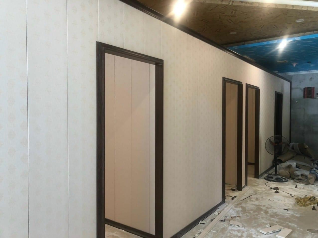 Hành lang với nhiều cửa và tường ốp gỗ trong quá trình xây dựng hoặc cải tạo nội thất.