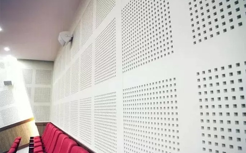 vach-thach-cao-cach-am-la-gi-1 Ghế đỏ trong phòng âm học với tường tiêu âm hình vuông trắng.