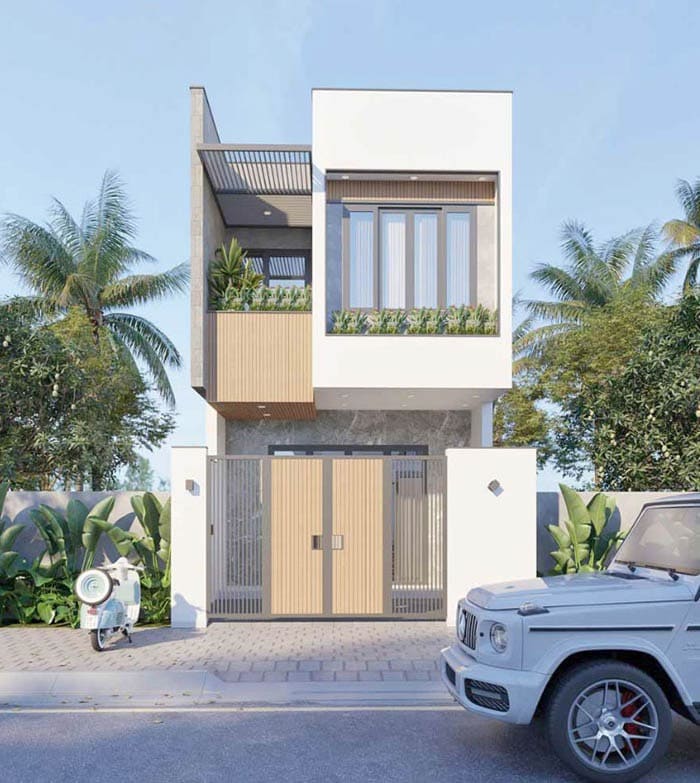 Nhà phố hiện đại hai tầng với cửa gỗ, xe ô tô và xe máy ngoài sân, xung quanh cây xanh, bầu trời trong xanh.