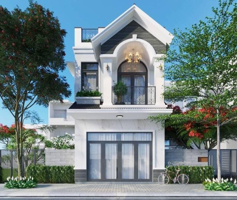 Nhà hai tầng hiện đại với cửa sổ lớn, ban công, cây cối xung quanh, bầu trời trong xanh.