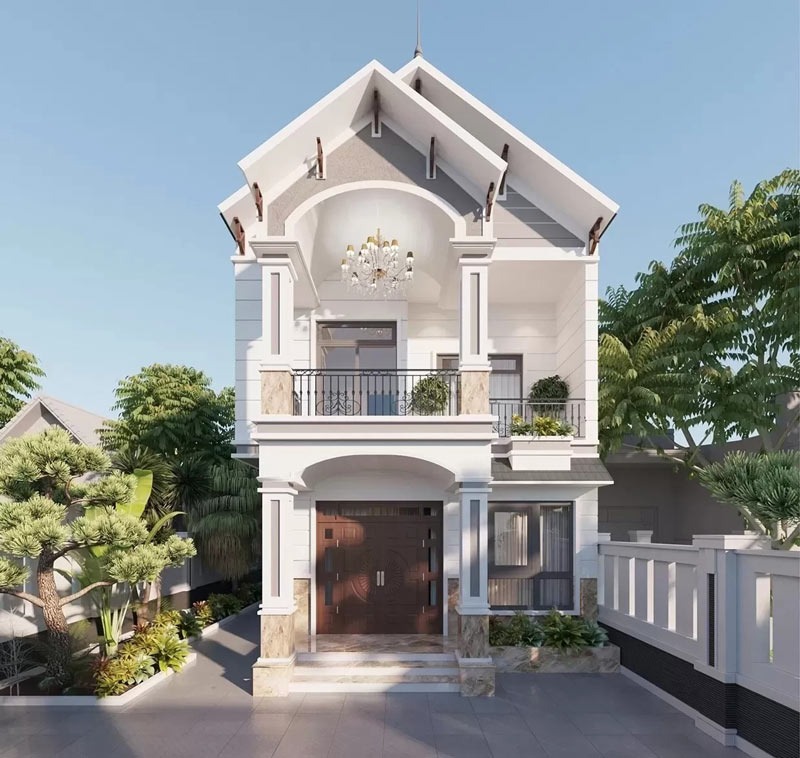 Mặt tiền ngôi nhà 2 tầng hiện đại, mái dốc, có ban công và cây xanh xung quanh, bầu trời trong xanh.