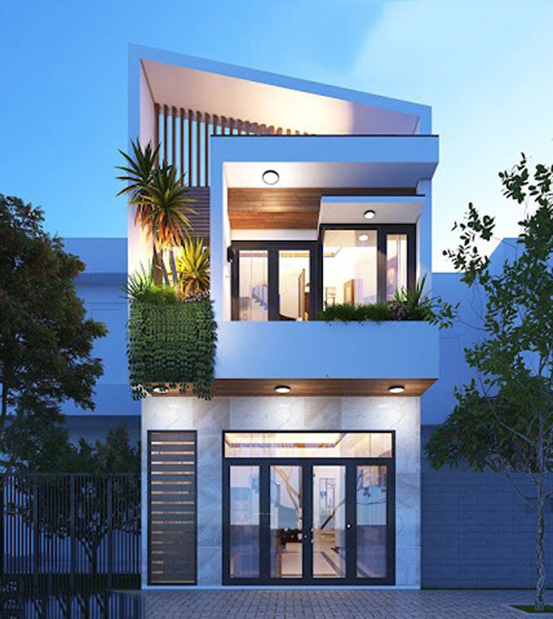 Nhà phố hiện đại với cây xanh trang trí, thiết kế mái lệch độc đáo và ánh sáng xung quanh vào ban đêm.