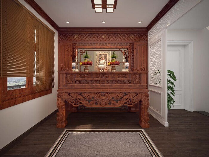 Bàn thờ gỗ sang trọng trong phòng thờ truyền thống, với hoa quả trang trí và cửa sổ ánh sáng tự nhiên.