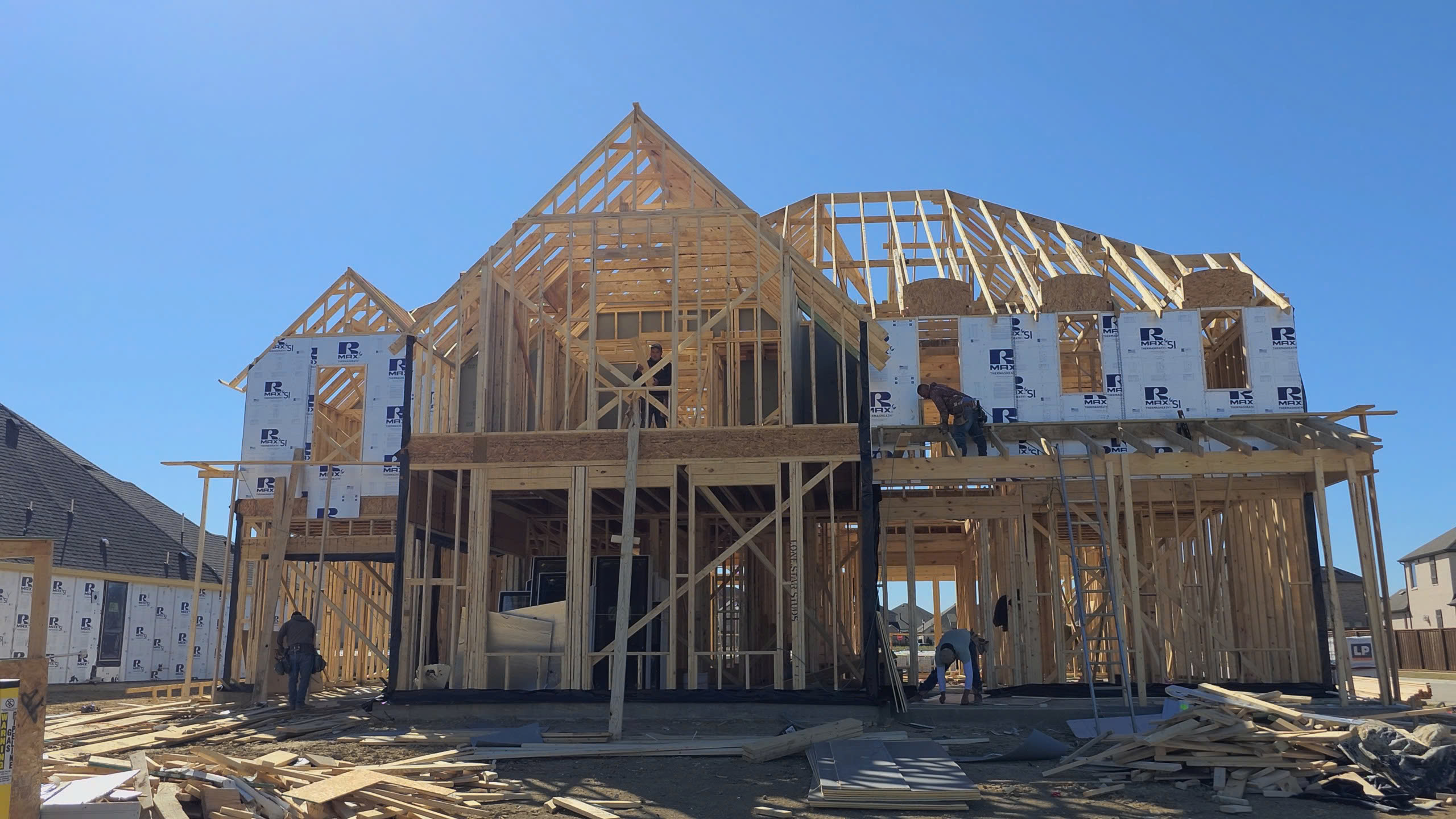 Công trình xây dựng nhà khung gỗ đang trong quá trình hoàn thiện dưới bầu trời xanh.